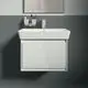 Waschbecken mit weißem Unterschrank und klarer Oberfläche, installiert an einer grauen Wand, ergänzt durch einen chromfarbenen Wasserhahn. Ideal Standard-Marke sichtbar.